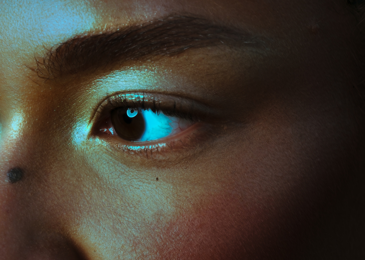 The image shows a close up of a woman's eye, there is an etherial dramatic quality to the shot.